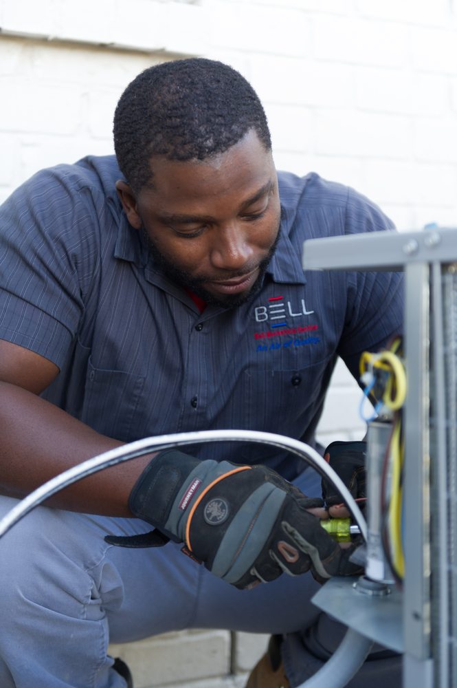 Bell Mechanical technician repairing HVAC equipment on the job