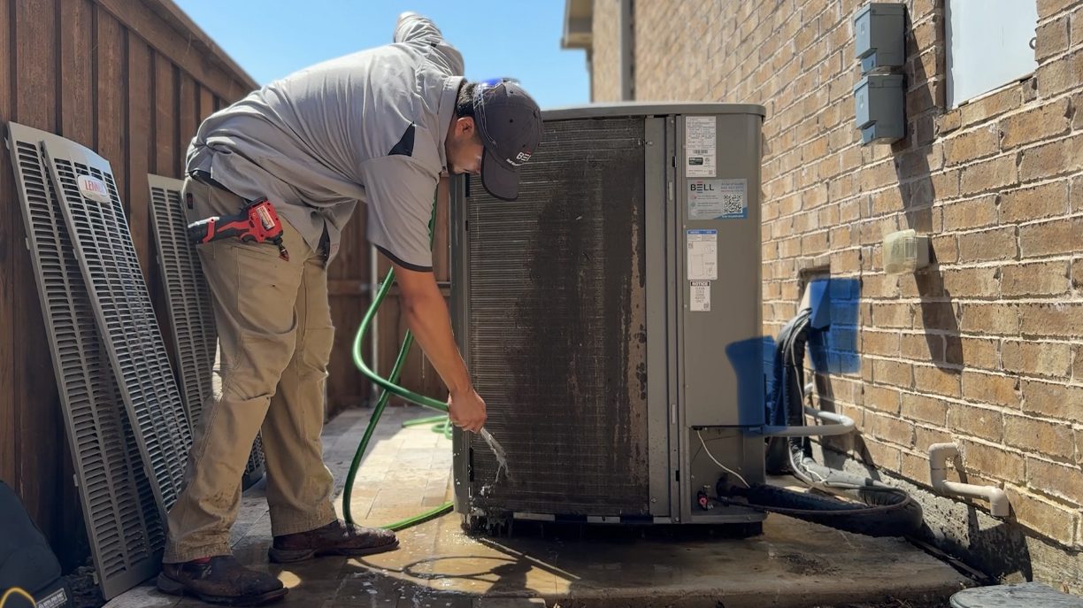 Bell Mechanical technician servicing an outdoor air conditioning condenser