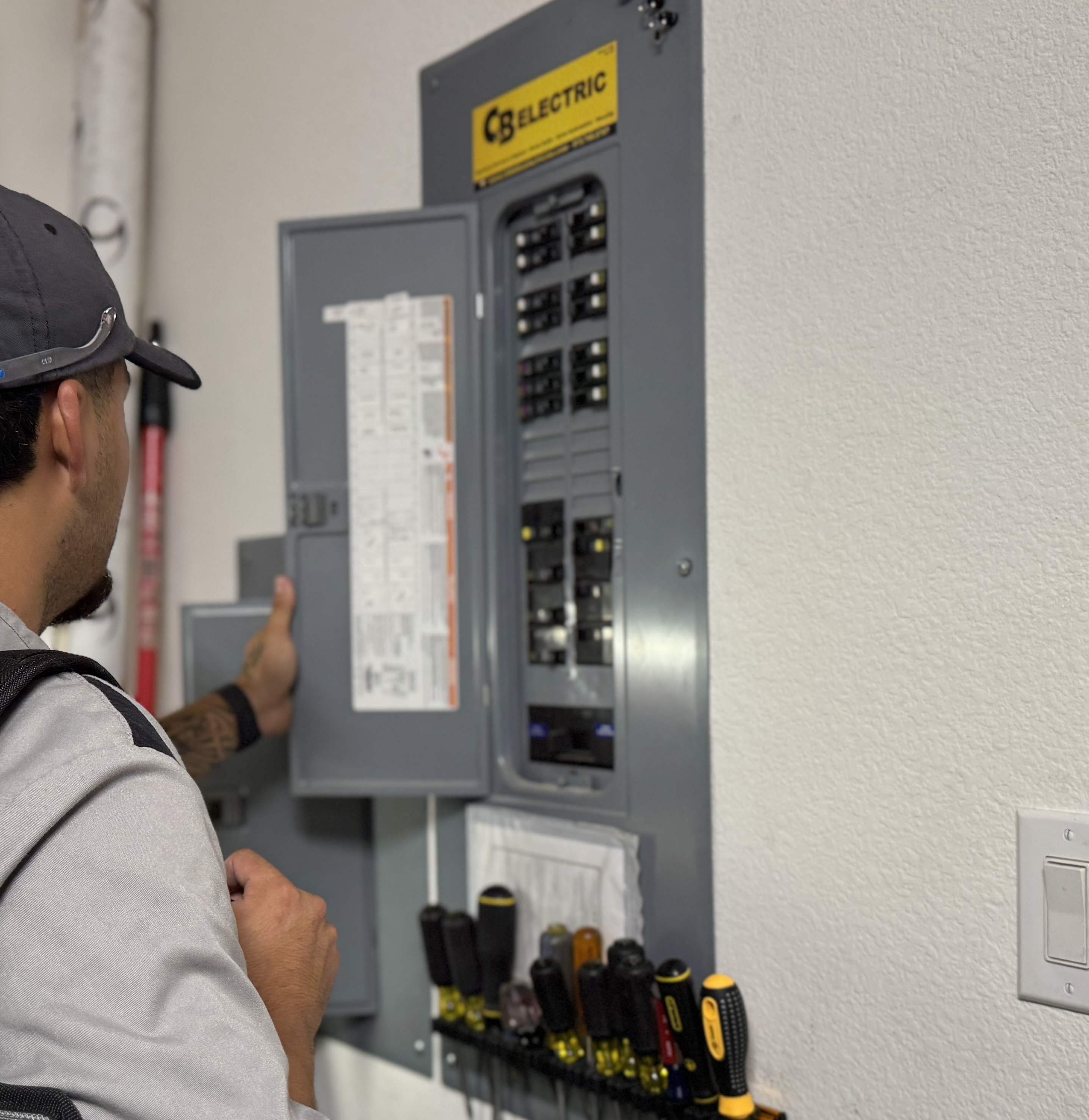 A Bell Mechanical technician inspects an electrical panel during a maintenance visit