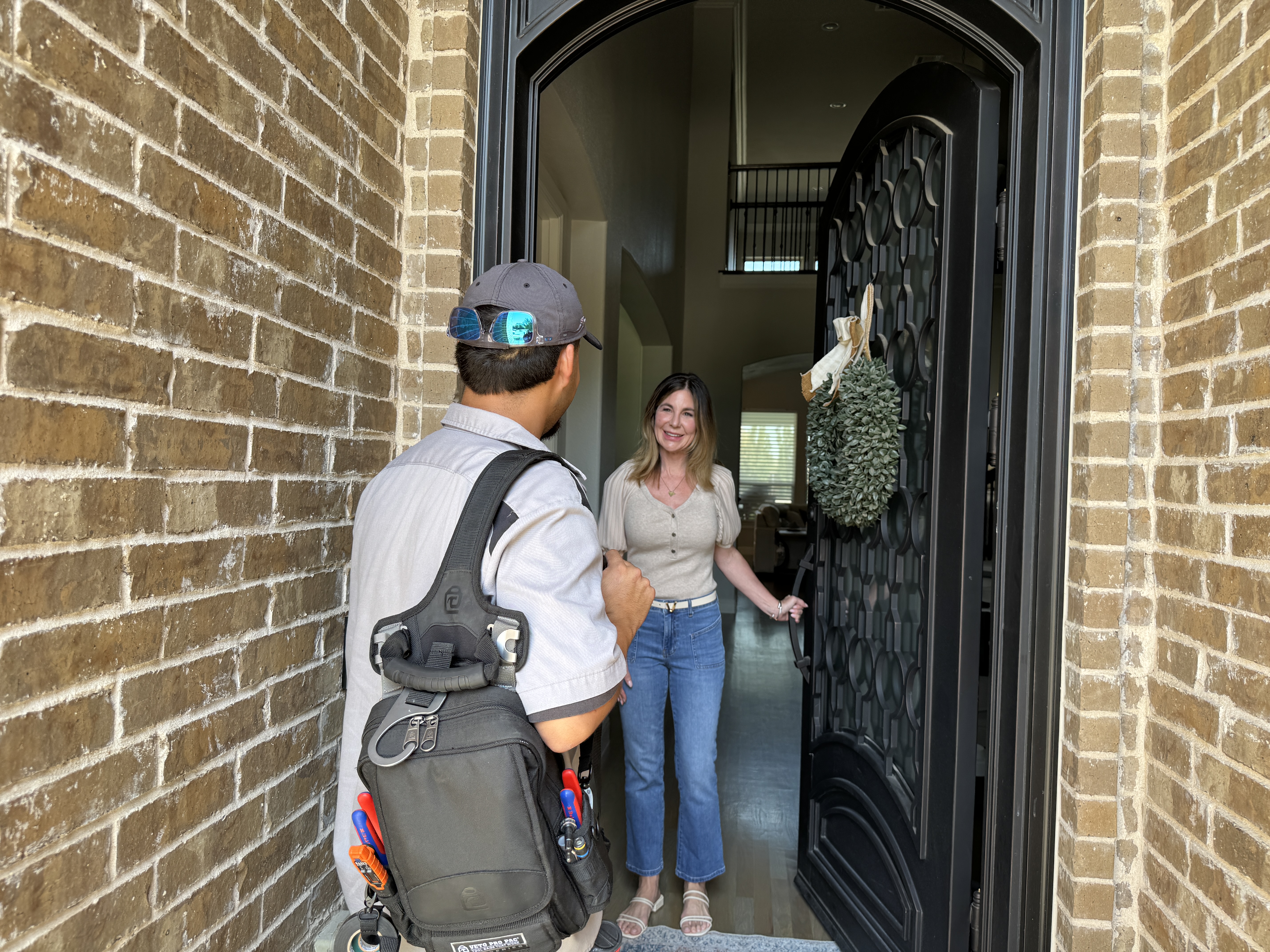 Bell Mechanical technician greeting homeowners at their front door